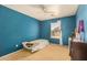 Cozy bedroom featuring light carpet, window and a ceiling fan at 514 N 112Th Dr, Avondale, AZ 85323