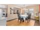 Elegant dining room with a modern chandelier, hardwood floors, and views into the living room at 514 N 112Th Dr, Avondale, AZ 85323