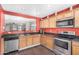Well-appointed kitchen with stainless steel appliances, dark countertops, and wooden cabinetry at 514 N 112Th Dr, Avondale, AZ 85323