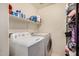 Bright laundry room with white washer and dryer and ample shelving for storage at 514 N 112Th Dr, Avondale, AZ 85323