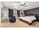 Bedroom boasts a ceiling fan, accent wall, large window, and cozy armchair at 514 N 112Th Dr, Avondale, AZ 85323