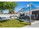 A luxurious backyard with artificial grass, a swimming pool, cozy seating, and an outdoor kitchen at 5320 E Thomas Rd, Phoenix, AZ 85018