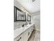 Modern bathroom featuring a dual sink vanity with marble countertop, decorative mirrors, and wood-look flooring at 5320 E Thomas Rd, Phoenix, AZ 85018