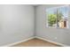 Simple, vacant bedroom with tan tile flooring, a large window, and neutral paint at 5320 E Thomas Rd, Phoenix, AZ 85018