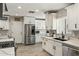 Bright kitchen featuring white cabinetry, stainless steel appliances, and wood-look flooring at 5320 E Thomas Rd, Phoenix, AZ 85018