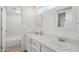 Bright bathroom featuring double sinks, quartz counters, framed mirrors, and tub-shower combo with marble surround at 610 E Montebello Ave # 46, Phoenix, AZ 85012