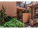 Charming exterior of home showcasing stucco, stone accents, private gate and lush greenery at 6940 E Cochise Rd # 1027, Paradise Valley, AZ 85253