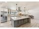 Bright, open kitchen featuring white cabinets, a large island with a cooktop, and modern lighting at 735 E Northern Ave, Phoenix, AZ 85020