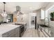 Bright kitchen with gray and white finishes, an island with bar stools, stainless steel appliances, and an open floor plan at 735 E Northern Ave, Phoenix, AZ 85020