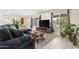 Bright living room with a comfortable sofa, a large TV, decorative plants, and view to the outside at 735 E Northern Ave, Phoenix, AZ 85020