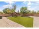 Backyard featuring artificial grass and desert landscaping, offering a low-maintenance and aesthetically pleasing outdoor space at 812 S Fern Ct, Gilbert, AZ 85296