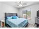 Serene bedroom with a ceiling fan, large window, comfortable bed, and neutral-toned walls at 812 S Fern Ct, Gilbert, AZ 85296