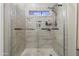 Bright shower featuring tiled walls and glass door with a shower head and decoratively tiled floor at 812 S Fern Ct, Gilbert, AZ 85296