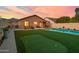 This backyard features a putting green, sparkling pool, and covered patio, perfect for outdoor relaxation and entertainment at 9013 E Shooting Star Dr, Gold Canyon, AZ 85118