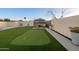 Spacious backyard featuring a putting green, turf lawn, and inviting seating area for relaxation at 9013 E Shooting Star Dr, Gold Canyon, AZ 85118
