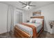 Bedroom with a wooden bedframe, ceiling fan, and view of the neighborhood outside the window at 9013 E Shooting Star Dr, Gold Canyon, AZ 85118