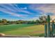 Scenic golf course view featuring vibrant green grass, mature trees, and a blue sky with wispy clouds at 9013 E Shooting Star Dr, Gold Canyon, AZ 85118