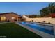 Backyard pool with turf, a covered patio and seating create an ideal outdoor retreat at 9013 E Shooting Star Dr, Gold Canyon, AZ 85118