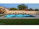 Sparkling pool with vibrant landscaping and turf, creating a relaxing and inviting backyard oasis at 9013 E Shooting Star Dr, Gold Canyon, AZ 85118