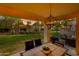 Relaxing back patio featuring a dining table, cushioned seating, and a view of the lush green lawn at 9121 W Topeka Dr, Peoria, AZ 85382