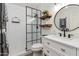 Modern bathroom features a glass-enclosed shower and floating wood shelves for storage at 9121 W Topeka Dr, Peoria, AZ 85382