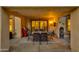 A beautifully decorated, covered patio with dining table, outdoor grill, and decorative water feature at 9121 W Topeka Dr, Peoria, AZ 85382