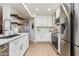 Modern kitchen with stainless steel appliances, white cabinets, and a stylish faucet at 9121 W Topeka Dr, Peoria, AZ 85382