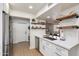 Updated kitchen featuring white cabinets, stainless steel appliances, and open wood shelves at 9121 W Topeka Dr, Peoria, AZ 85382