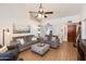 Bright living room featuring a high ceiling, wood-look floors, and cozy gray couches at 9121 W Topeka Dr, Peoria, AZ 85382