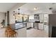 Bright kitchen showcasing modern appliances, white cabinets, dark countertops, and a breakfast bar with natural lighting at 9221 N Camino Vista Ln, Phoenix, AZ 85028