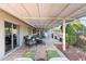 Inviting covered patio with comfortable seating, outdoor dining area, and lush landscaping at 9221 N Camino Vista Ln, Phoenix, AZ 85028