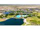 Aerial view of a community pool, lake, and recreation center, surrounded by lush landscaping at 16683 S 180Th Dr, Goodyear, AZ 85338