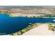 Aerial view of a serene lake with palm trees, a dock, and desert surroundings at 16683 S 180Th Dr, Goodyear, AZ 85338
