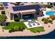 Backyard featuring covered patio with outdoor seating, lush landscaping, and lake views at 16683 S 180Th Dr, Goodyear, AZ 85338