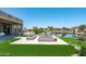 Inviting backyard features a lake view, patio with ample seating, and well-manicured artificial grass at 16683 S 180Th Dr, Goodyear, AZ 85338