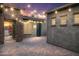 Exterior view of a beautifully lit courtyard with decorative pavers and arched entryway at 16683 S 180Th Dr, Goodyear, AZ 85338