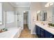 Bathroom with double sink vanity, soaking tub, and glass-enclosed shower at 16683 S 180Th Dr, Goodyear, AZ 85338