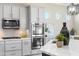 Well-equipped kitchen features stainless steel appliances, light gray cabinets, light countertops, and a center island at 16683 S 180Th Dr, Goodyear, AZ 85338