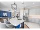 Open concept kitchen features gray cabinets, stainless appliances, island with breakfast bar, and opens to the living room at 16683 S 180Th Dr, Goodyear, AZ 85338