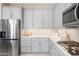 Bright kitchen features stainless steel appliances, light gray cabinets, light countertops, and tiled backsplash at 16683 S 180Th Dr, Goodyear, AZ 85338