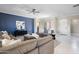 Open concept living room features a blue accent wall, neutral furniture, and tile floors at 16683 S 180Th Dr, Goodyear, AZ 85338