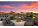 Comfortable outdoor living space with stylish seating around a stone fire pit near the water at 16683 S 180Th Dr, Goodyear, AZ 85338