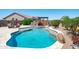 This stunning pool boasts a stone waterfall feature and ample space for lounging and entertaining guests at 16683 S 180Th Dr, Goodyear, AZ 85338