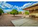 Expansive backyard with a covered patio area, gravel landscaping, and mature trees at 2245 Leisure World --, Mesa, AZ 85206