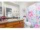 Well-lit bathroom with a granite countertop, floral shower curtain, and decorative mirror accents at 2245 Leisure World --, Mesa, AZ 85206