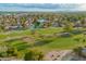 Aerial view of a well-manicured golf course winding through a community with mature trees and a serene lake at 2245 Leisure World --, Mesa, AZ 85206