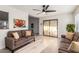 Inviting living room with neutral colored sofas, tile floors, and sliding glass doors that provide natural light at 2245 Leisure World --, Mesa, AZ 85206