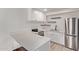 Well-lit kitchen with white cabinets, stone countertops, stainless appliances, and open shelving at 1006 E Osborn Rd # B, Phoenix, AZ 85014