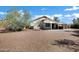 Large backyard offers a covered patio, desert landscaping, and mature trees at 1120 S Valley Dr, Apache Junction, AZ 85120