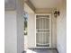 Covered entryway featuring a security screen door and exterior lighting at 1120 S Valley Dr, Apache Junction, AZ 85120